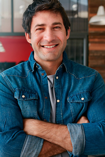 Hombre de mediana edad sonriendo con los brazos cruzados